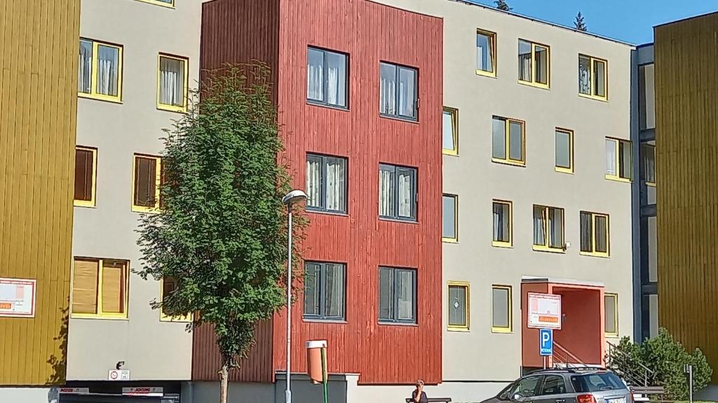 un edificio rojo al lado de una calle en Harrachovský apartmán, en Harrachov