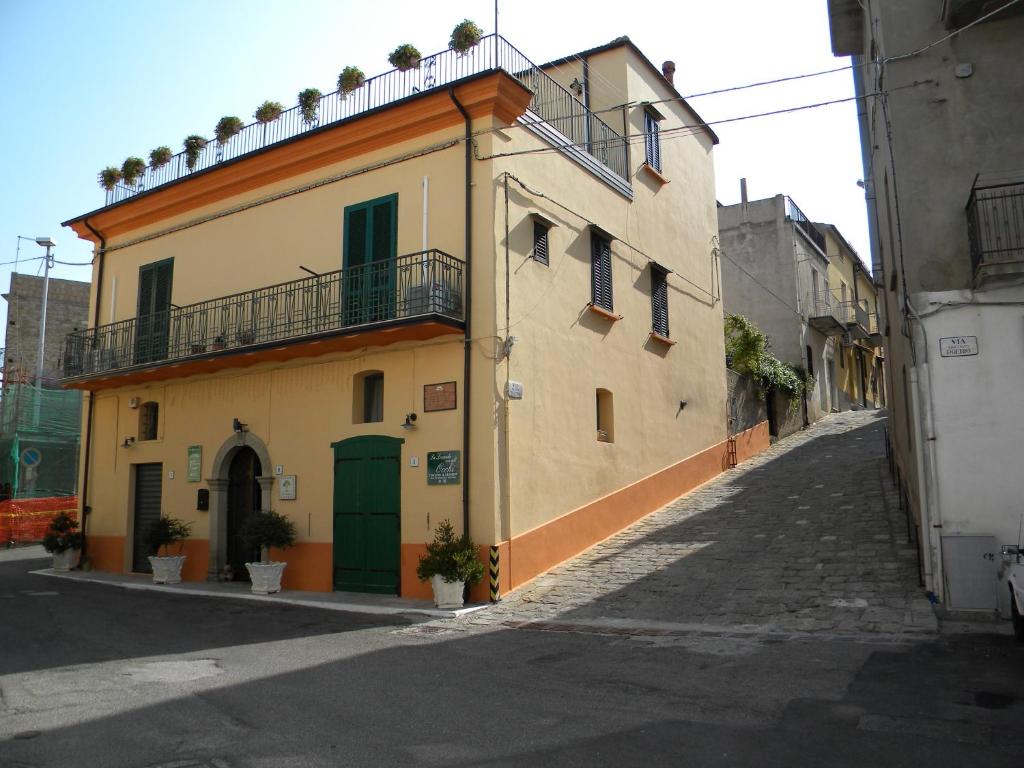 un edificio giallo con una porta verde su una strada di La Casa dellAmericano - Casa d'epoca anni '30 ad Aliano