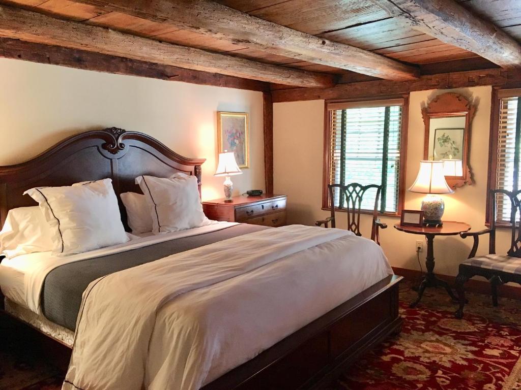 a bedroom with a large bed and two windows at The 1708 House in Southampton