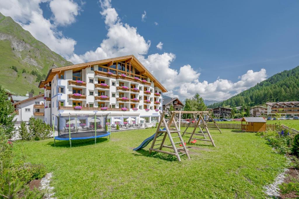 a large building with a playground in front of it at Hotel Nevada in Samnaun