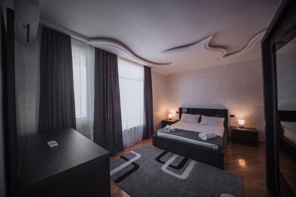 een slaapkamer met een bed en een groot raam bij Makos Guest House in Koetaisi