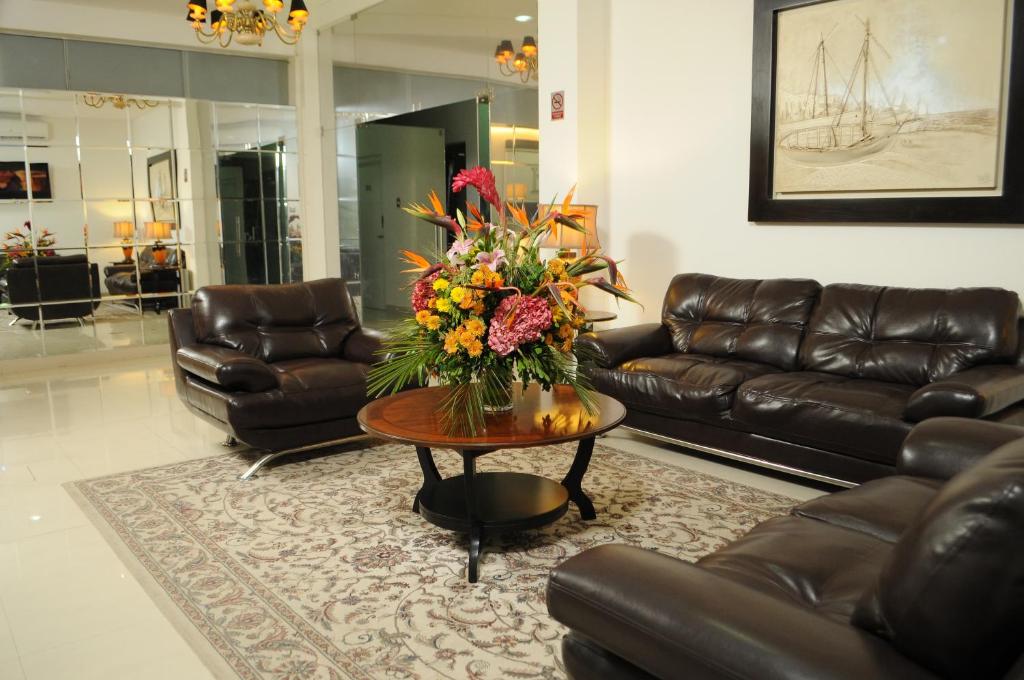 a living room with a couch and a table with flowers at Ixnuk Class in Piura