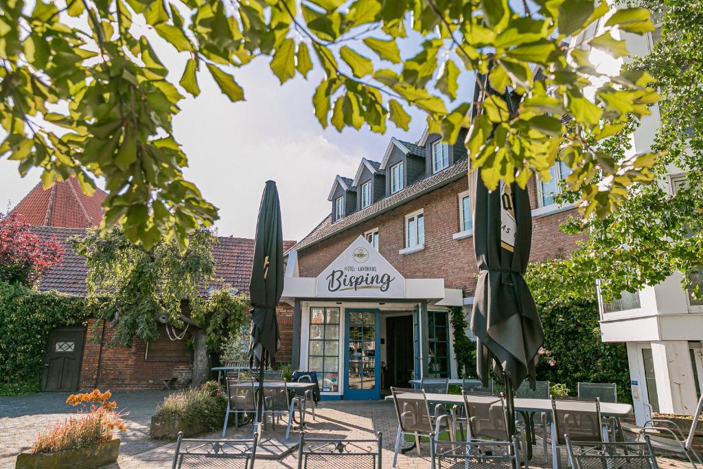 a cafe with tables and chairs in front of a building at Landhaus Bisping in Everswinkel