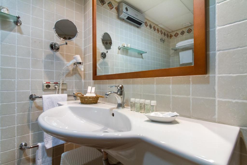 a bathroom with a white sink and a mirror at Hotel Tossal d'Altea in Altea