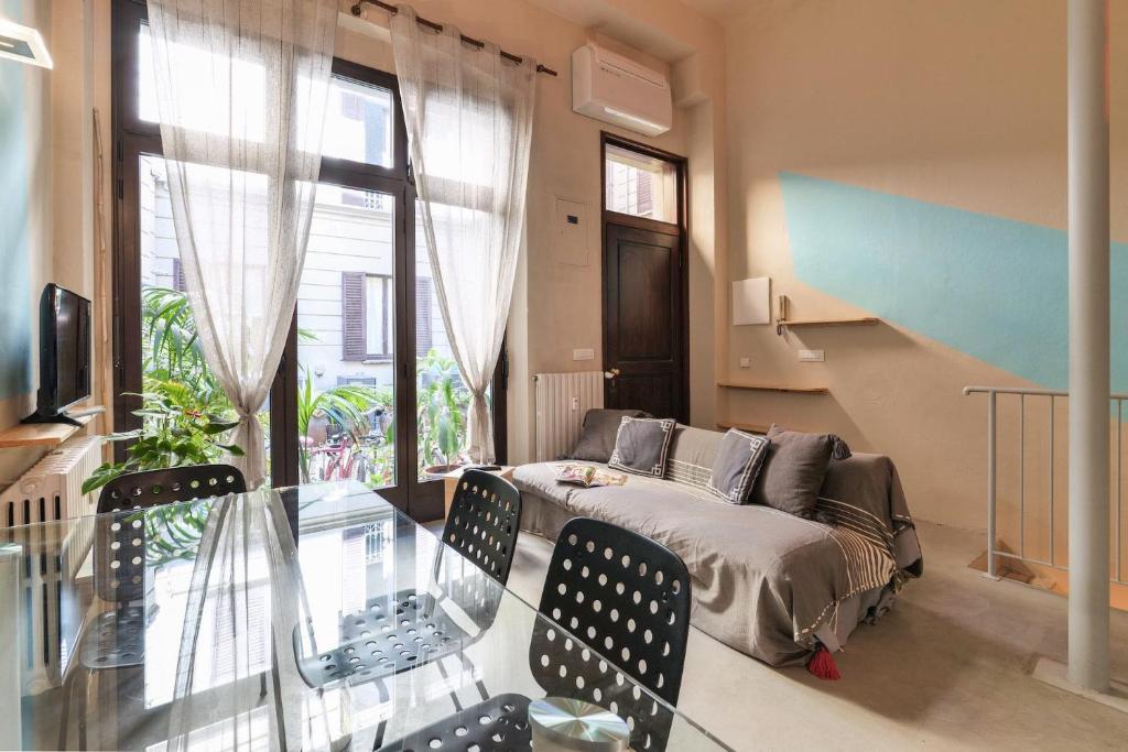 - un salon avec un canapé et une table en verre dans l'établissement Contempora Apartments - Saffi 12, à Milan