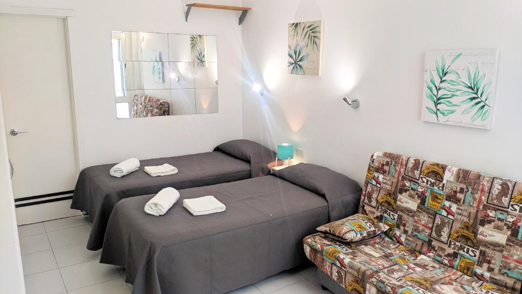sala de estar con 2 camas y sofá en Canteras Beach Lovely Loft *****, en Las Palmas de Gran Canaria