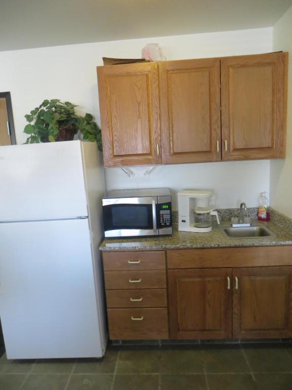 a kitchen with a white refrigerator and a microwave at Travelodge by Wyndham Missouri Valley in Missouri Valley