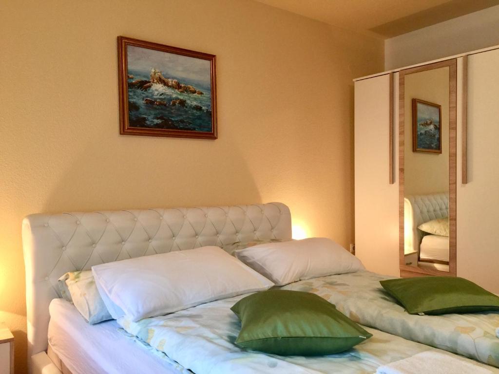 斯盧尼的住宿－Apartment Garden，床上有两张绿色枕头