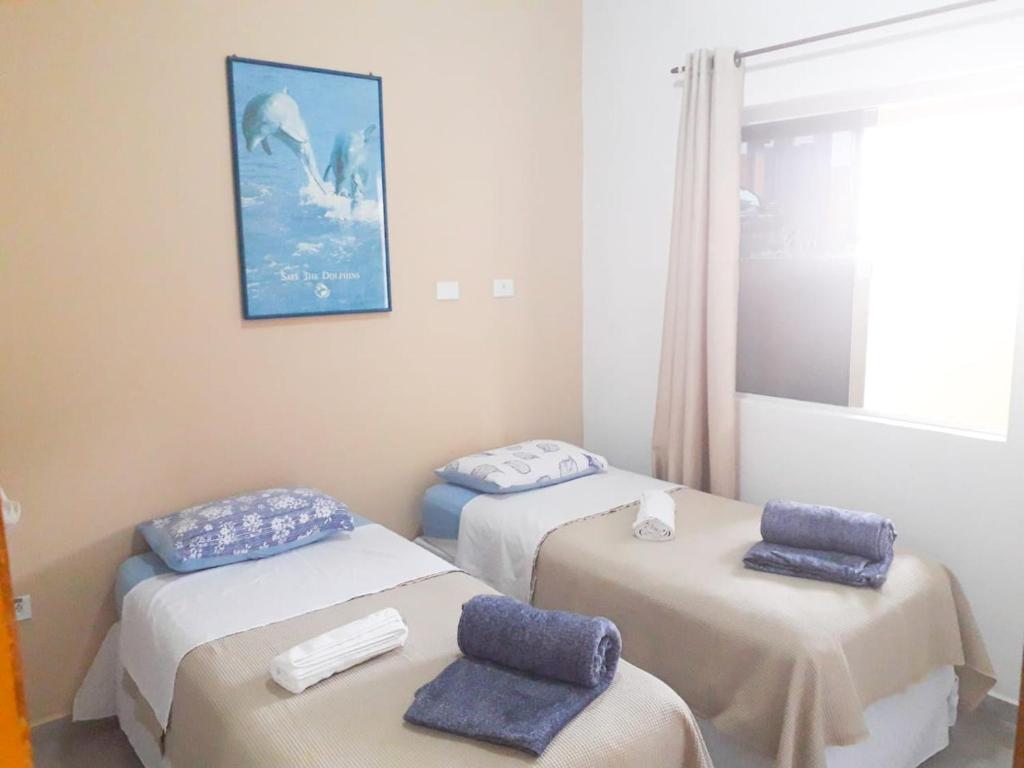 um quarto com duas camas com toalhas azuis em Casa do Mar & Ane Ilhabela em Ilhabela