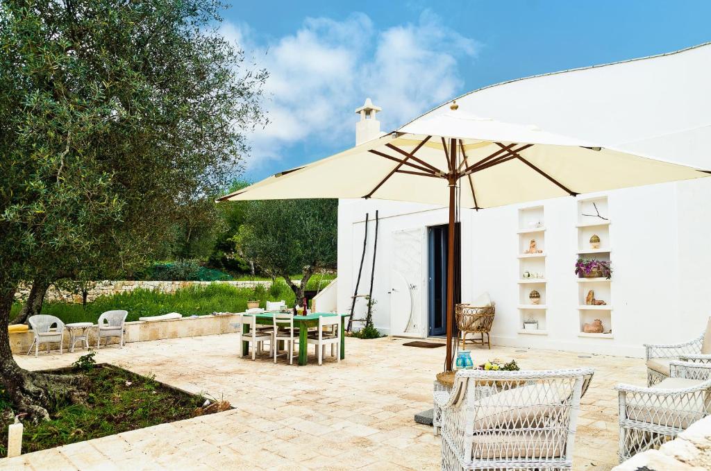 a patio with an umbrella and a table and chairs at 2 bedrooms house with private pool and furnished garden at Ceglie Messapica in Ceglie Messapica