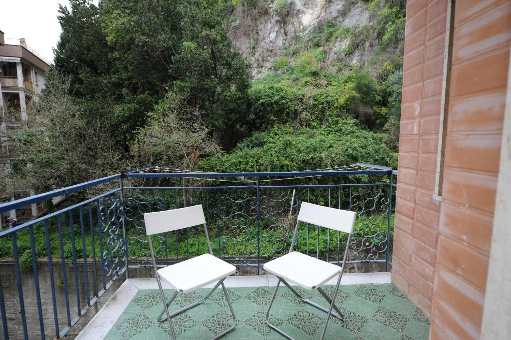 2 sillas blancas sentadas en un balcón en One bedroom apartement at Maiori 50 m away from the beach with furnished balcony and wifi, en Maiori