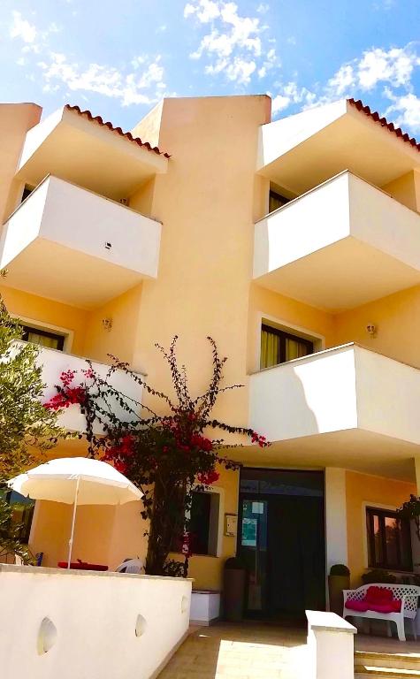 a yellow building with an umbrella in front of it at Palau City Hotel in Palau