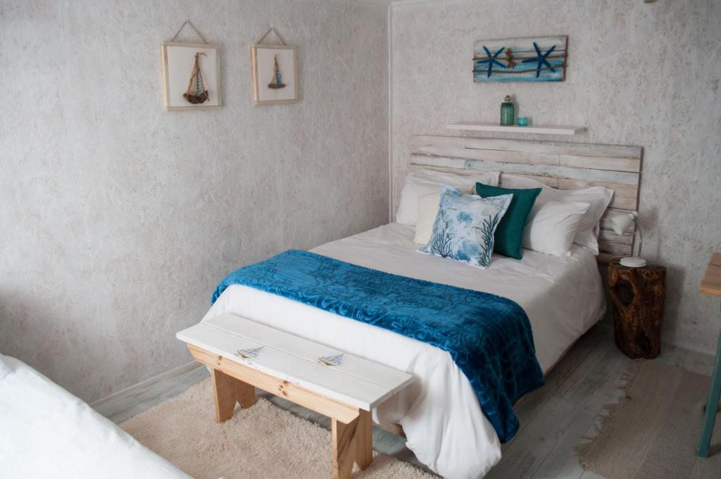 1 dormitorio con 1 cama con manta azul y mesa en Brakvlei 2, en Albertinia