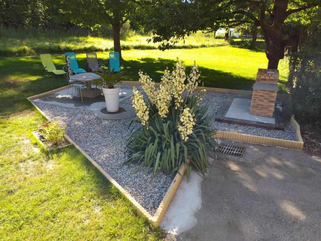 a garden with a bench and flowers in the grass at Le mas des Alberges in Le Bourg-dʼOisans