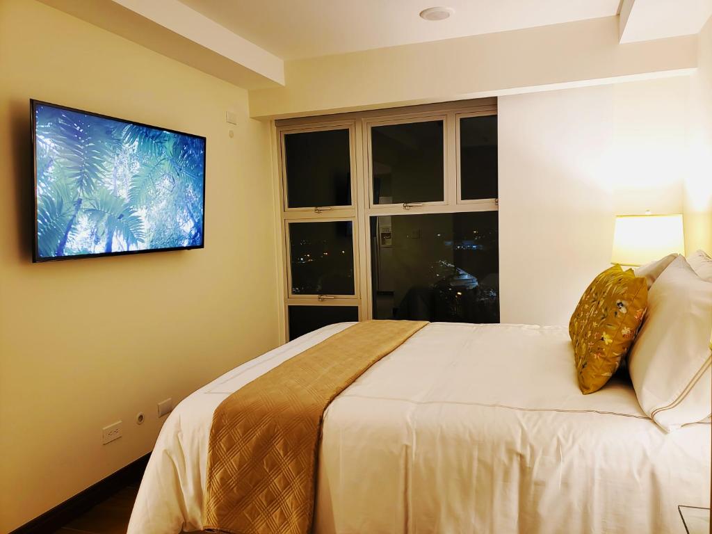 a bedroom with a bed and a tv on the wall at Alameda Cariari Apartments in San José