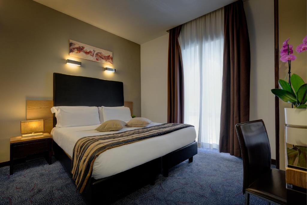 una camera d'albergo con letto e finestra di Hotel Rinascimento - Gruppo Trevi Hotels a Roma