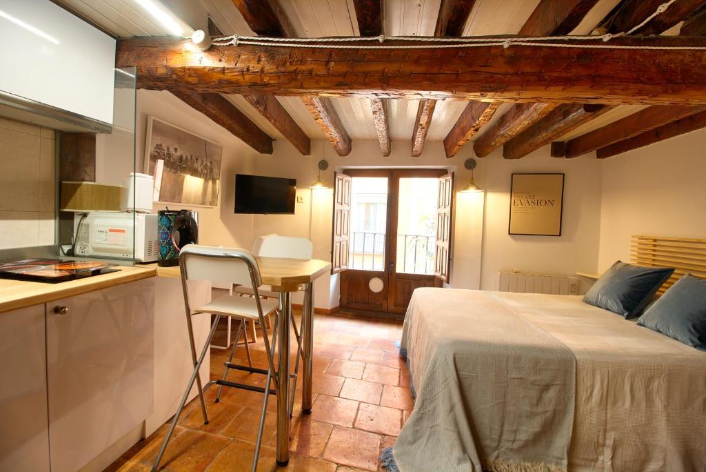 een keuken en een slaapkamer met een bed en een tafel bij CuencaLoft Alojamientos Solla in Cuenca