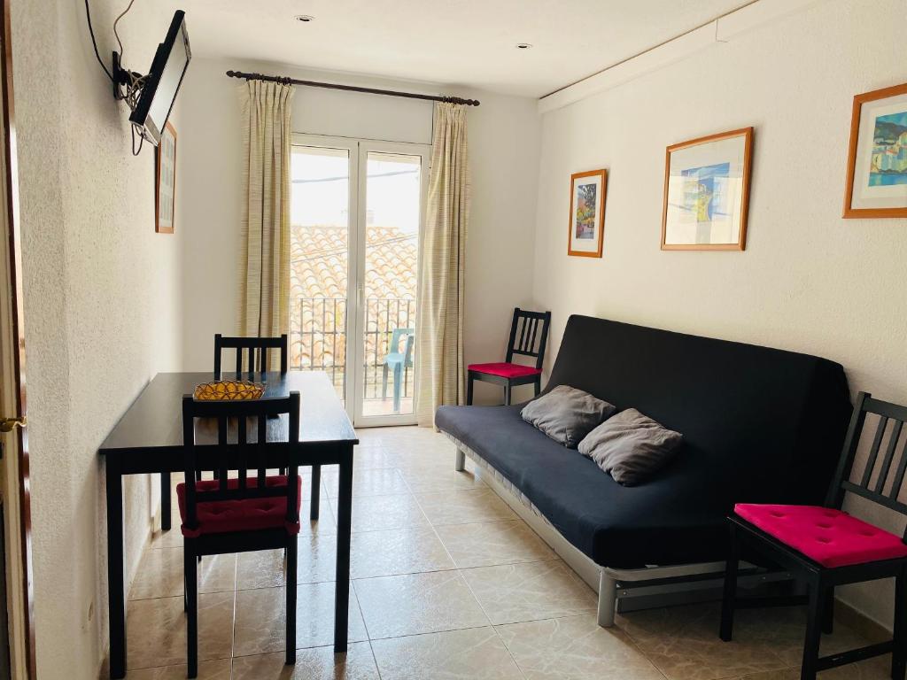 ein Wohnzimmer mit einem Sofa und einem Tisch in der Unterkunft Apartamentos Mitus in Canet de Mar