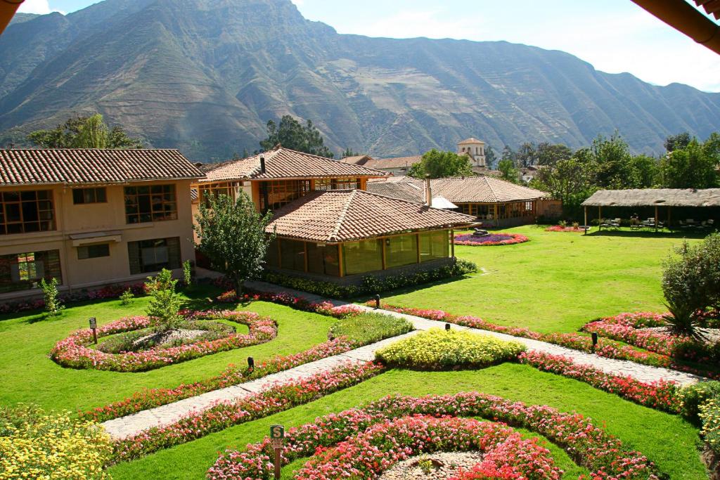 un jardín con flores en la hierba con una montaña en Hotel La Casona De Yucay Valle Sagrado, en Urubamba