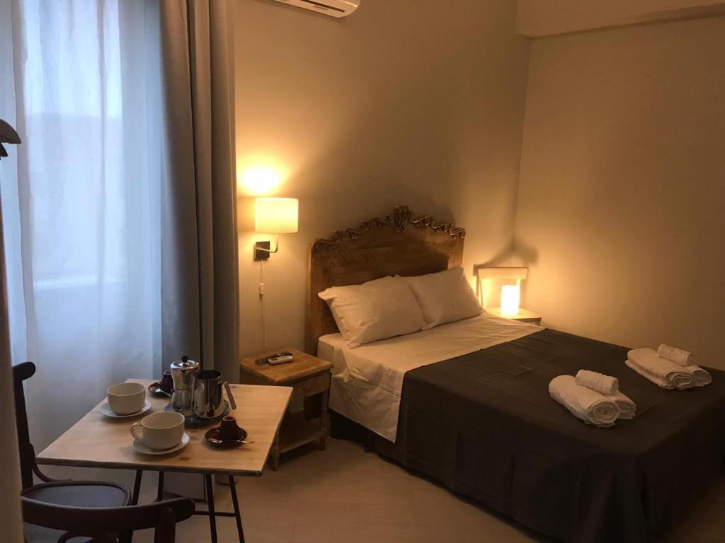 ein Hotelzimmer mit einem Bett und einem Tisch mit einem Tisch in der Unterkunft " DOMUS CORALLA" BnB Racconti Di Viaggio in Catania