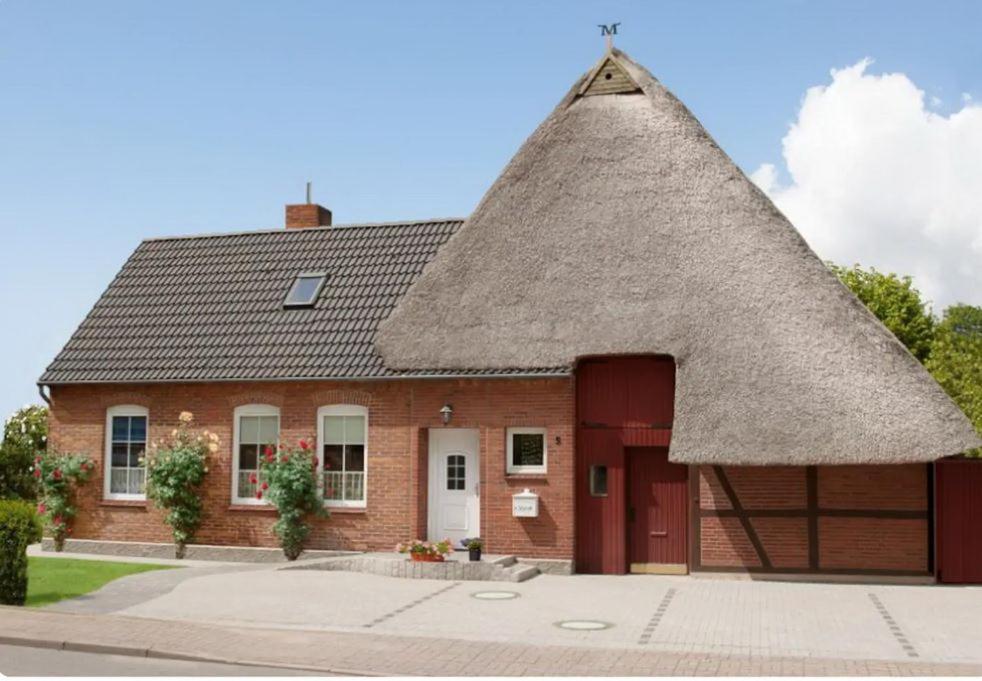 a small brick house with a thatched roof at Schönberg - Schuster Raths Kate in Schönberg in Holstein