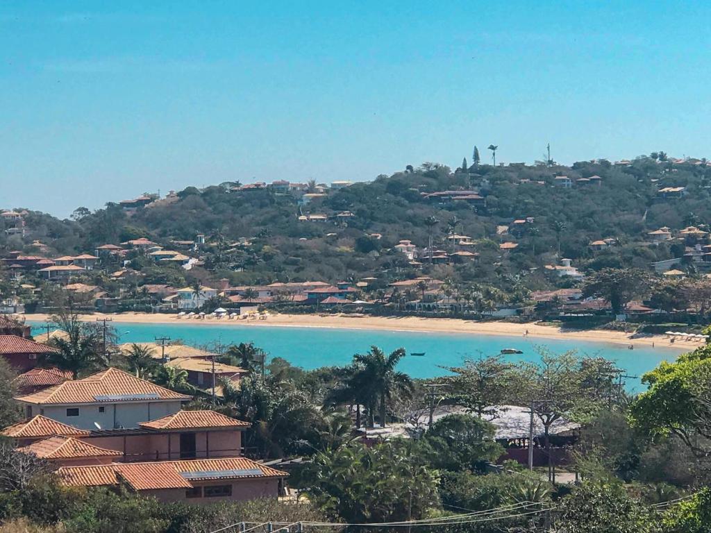 a view of a beach with houses on a hill at Vivamar Ferradura in Búzios