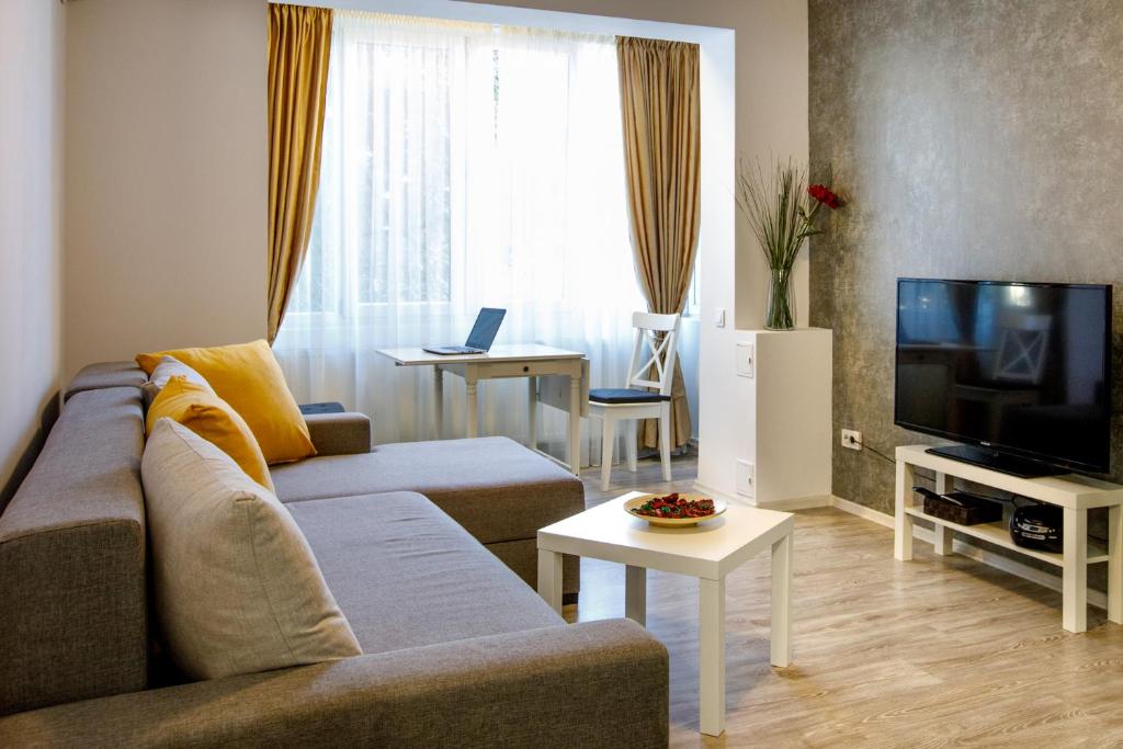 a living room with a couch and a television at Aquarium Apartment Grivita in Bucharest