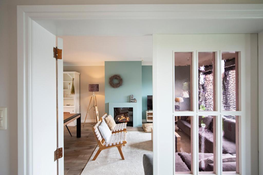 Huize Idalie في بلزن: غرفة معيشة مع أريكة ومدفأة