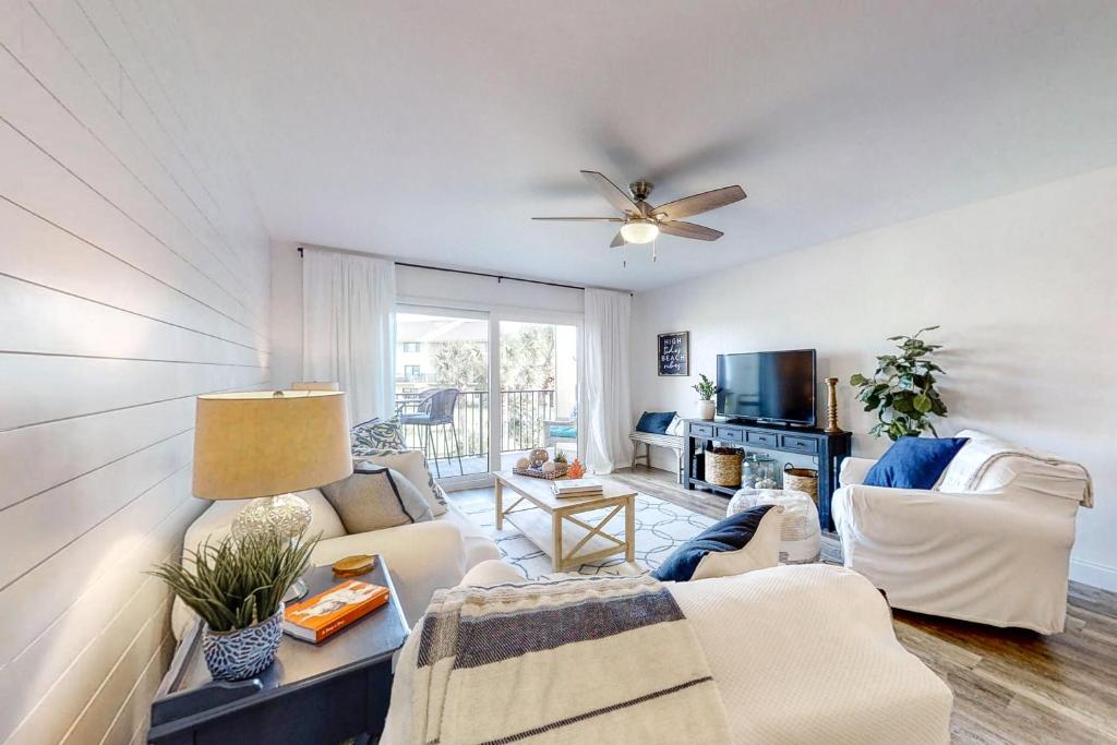 un soggiorno con un divano e un ventilatore a soffitto di Oceanfront condo with direct beach access, shared pool, tennis a Fort Matanzas