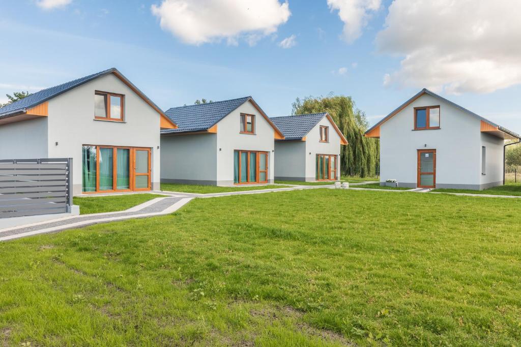 a row of white houses with a green yard w obiekcie Przystań 44 w Świnoujściu