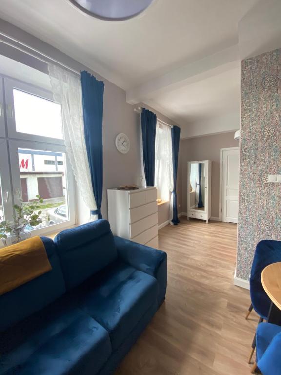 a living room with a blue couch and a table at Apartamenty Liwa in Kwidzyn