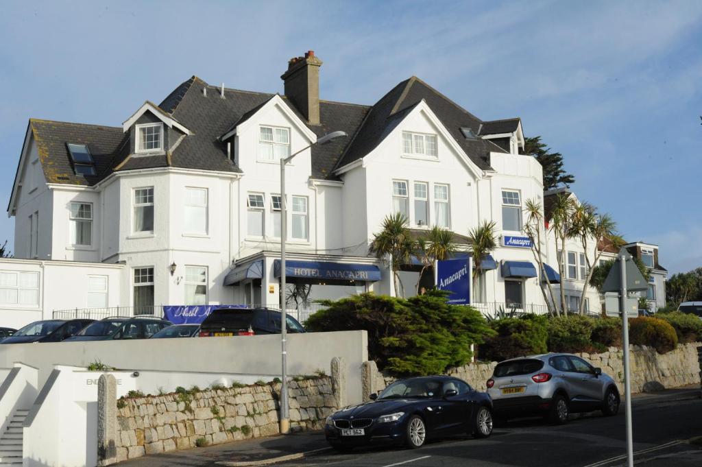 two cars parked in front of a white house at Anacapri in Falmouth