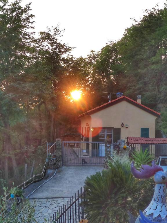 a house with the sun setting in front of it at A me ca picita in Stella
