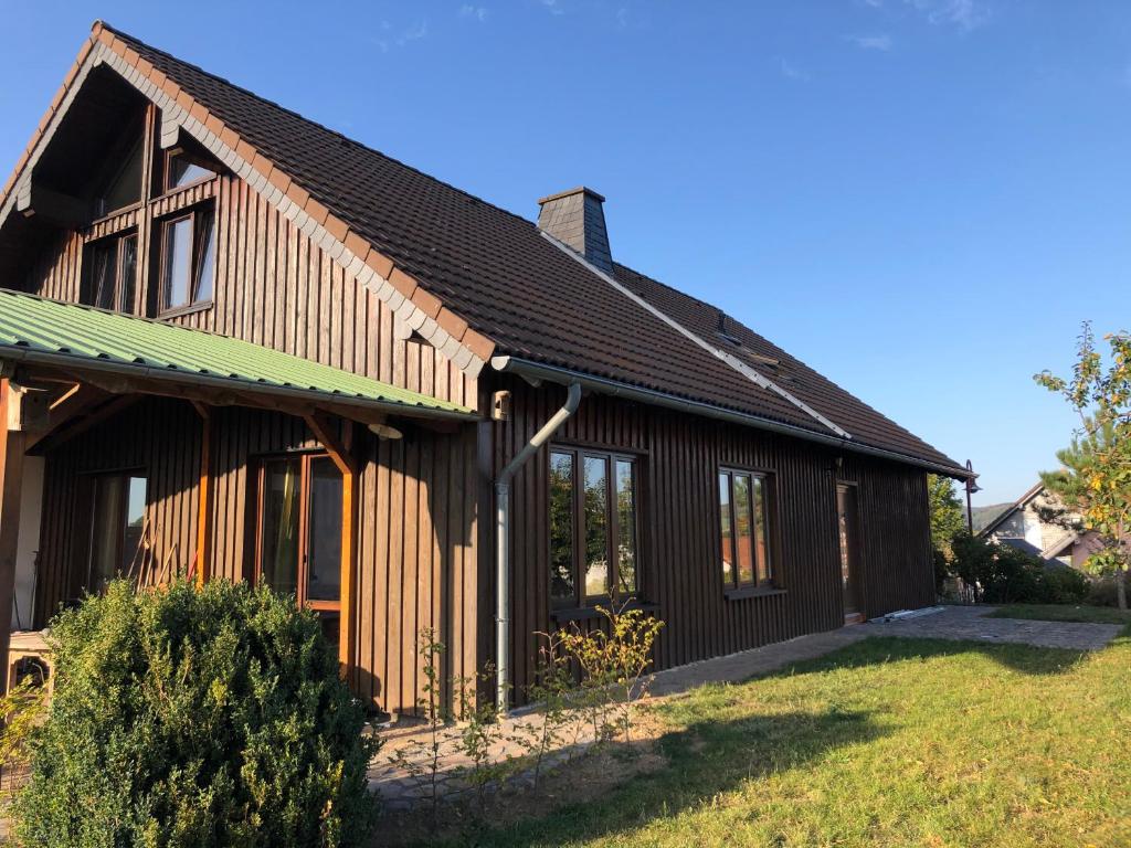 ein Holzhaus mit grünem Dach in der Unterkunft Waldhaus-Vulkaneifel in Kelberg