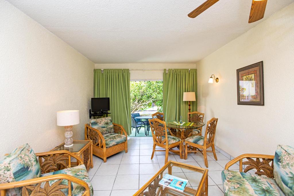 a living room with a couch and chairs and a table at Plum Tree Club in Bridgetown