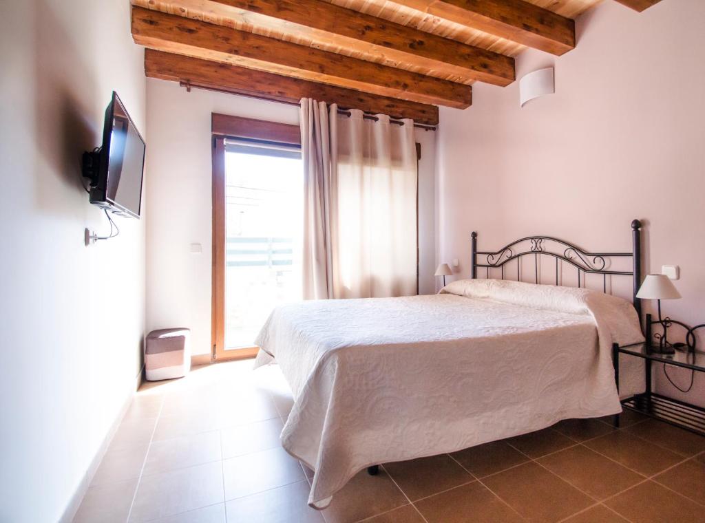 a bedroom with a bed and a large window at Apartamentos LA PARRA in Buitrago del Lozoya