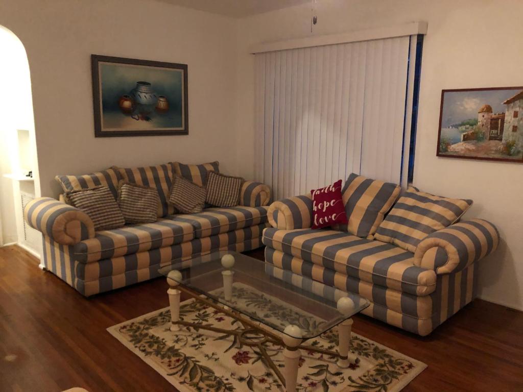 a living room with two couches and a coffee table at Beautiful Quiet Neighborhood in Miami