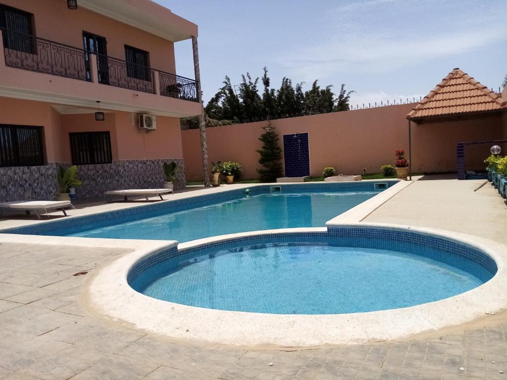 une piscine en face d'un bâtiment dans l'établissement Villa Louly, à Sali Nianiaral