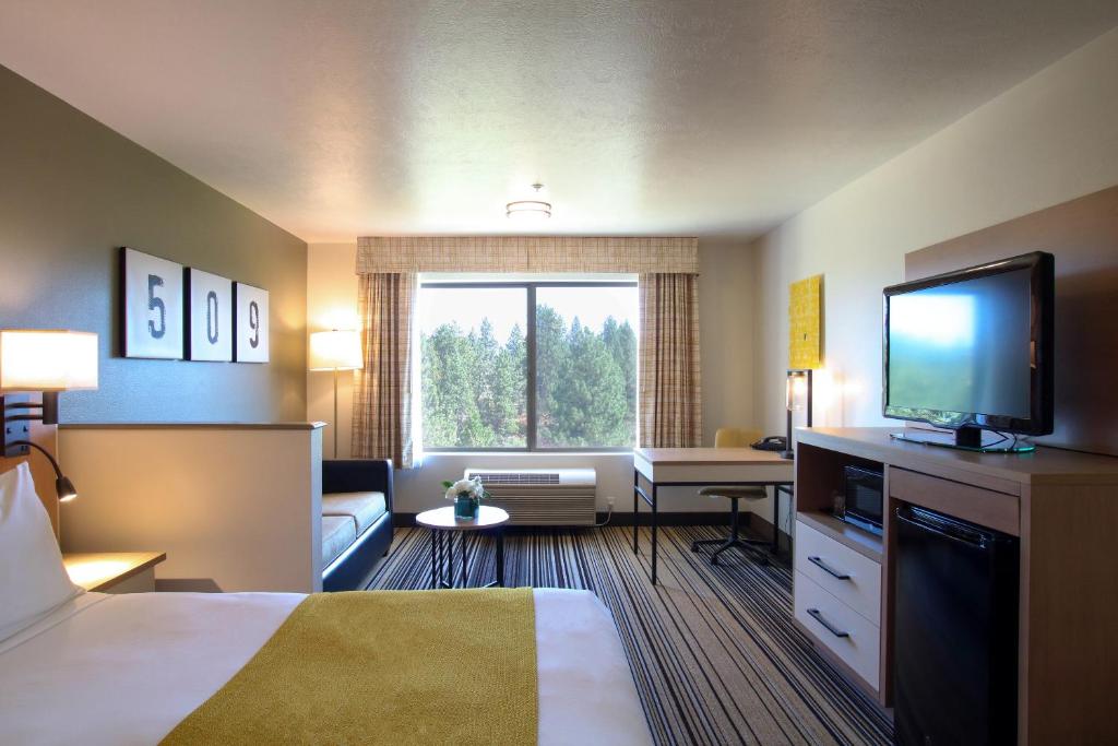 a hotel room with a bed and a flat screen tv at Oxford Suites Spokane Valley in Spokane Valley