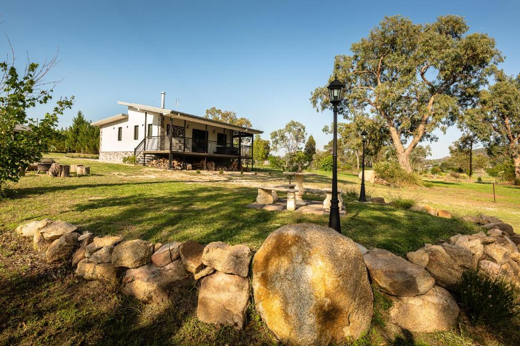 a house with a rock wall in front of a house at Bella Vista Stanthorpe in Stanthorpe