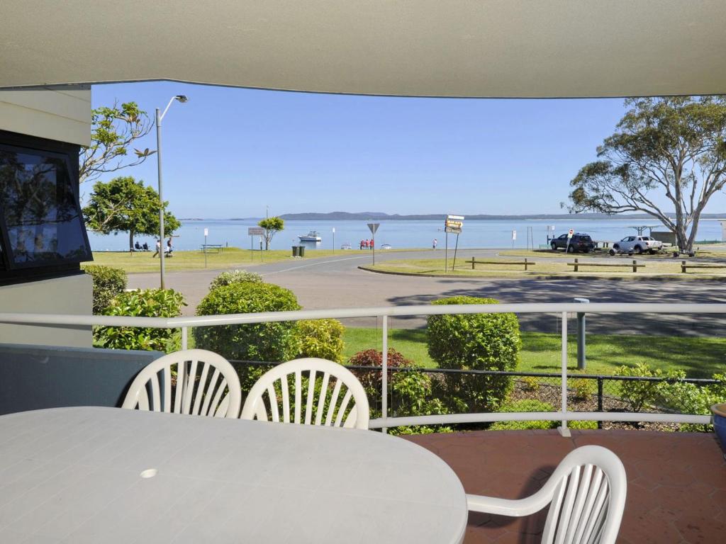 a balcony with a table and chairs and a view of the ocean at Florentine 3 Ground floor Unit with Lift and Sensational Water views in Nelson Bay