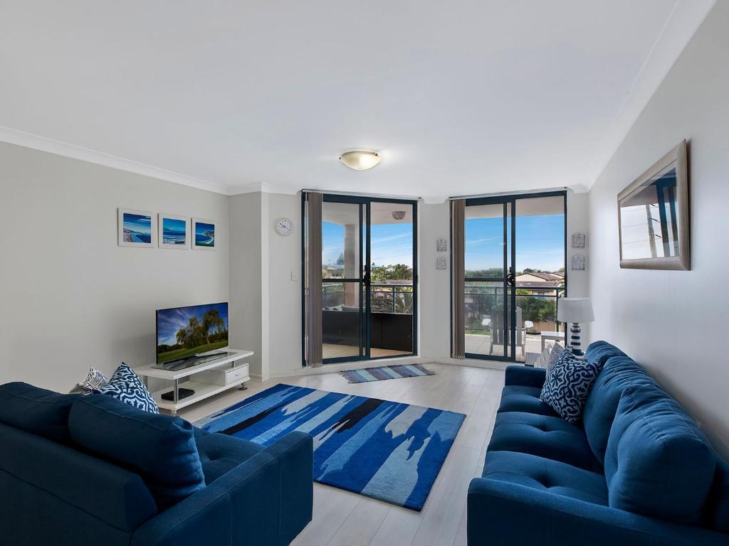 a living room with blue couches and a blue rug at Twin Shores 67 in The Entrance