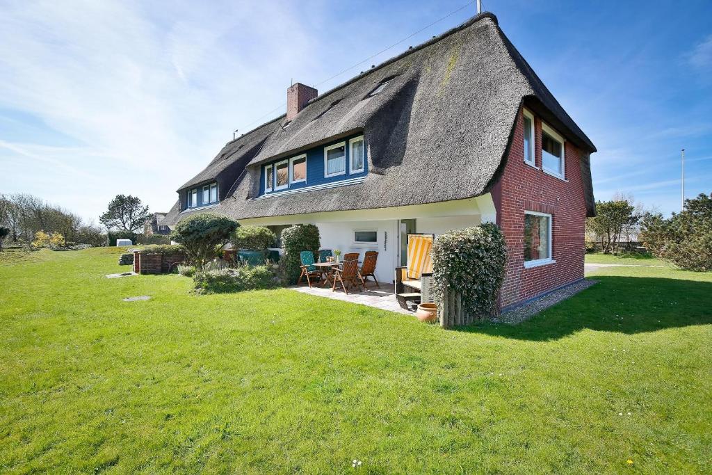 una casa de ladrillo rojo con un patio de hierba en Braderuper Heide, en Braderup