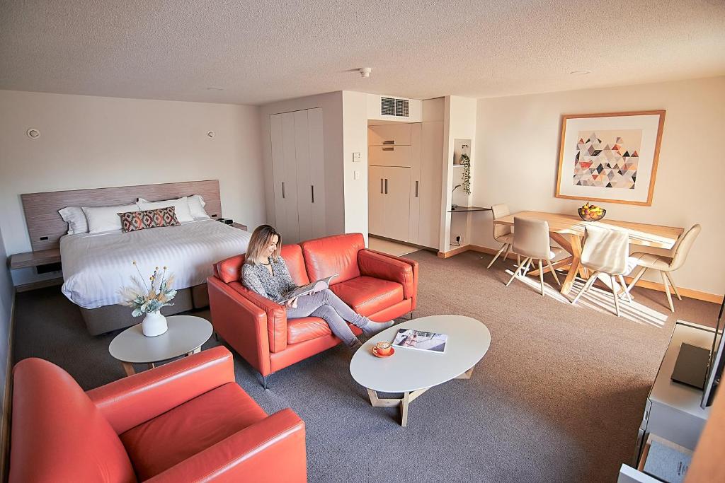 uma mulher sentada num sofá num quarto de hotel em Salamanca Inn em Hobart
