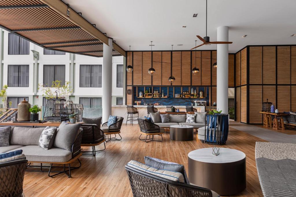 eine Lobby mit Sofas, Tischen und einer Bar in der Unterkunft Four Points by Sheraton Phuket Patong Beach Resort in Patong Beach