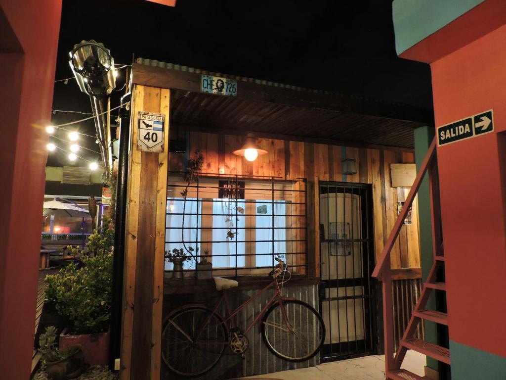 Una bicicleta estacionada fuera de un edificio por la noche en Carrusel Art-Hostel en Mar del Plata