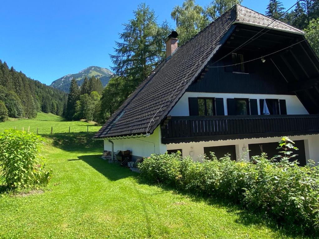 una casa con techo negro en un campo verde en Landhaus am Pyhrn en Pyhrn