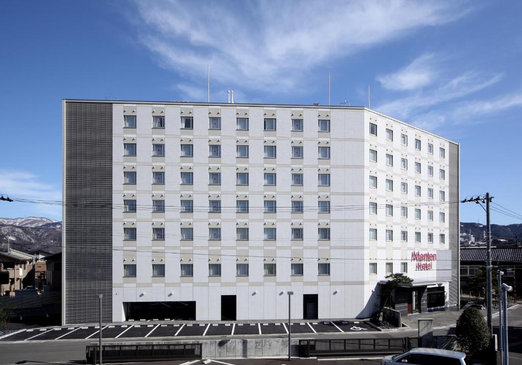 a large white building with a lot of windows at Tsuruga Manten Hotel Ekimae in Tsuruga