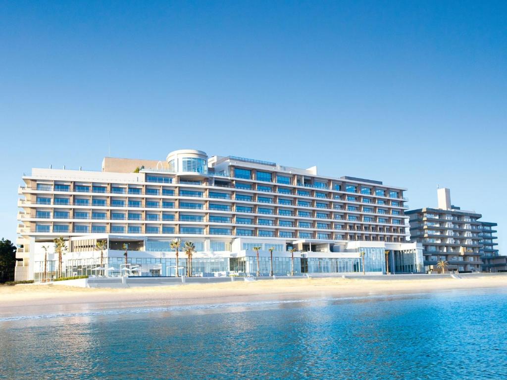 a large building on the beach next to the water at Karatsu Seaside Hotel in Karatsu