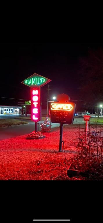 a neon sign for a restaurant with a sign for a limit at Diamond Motel - Abilene in Abilene